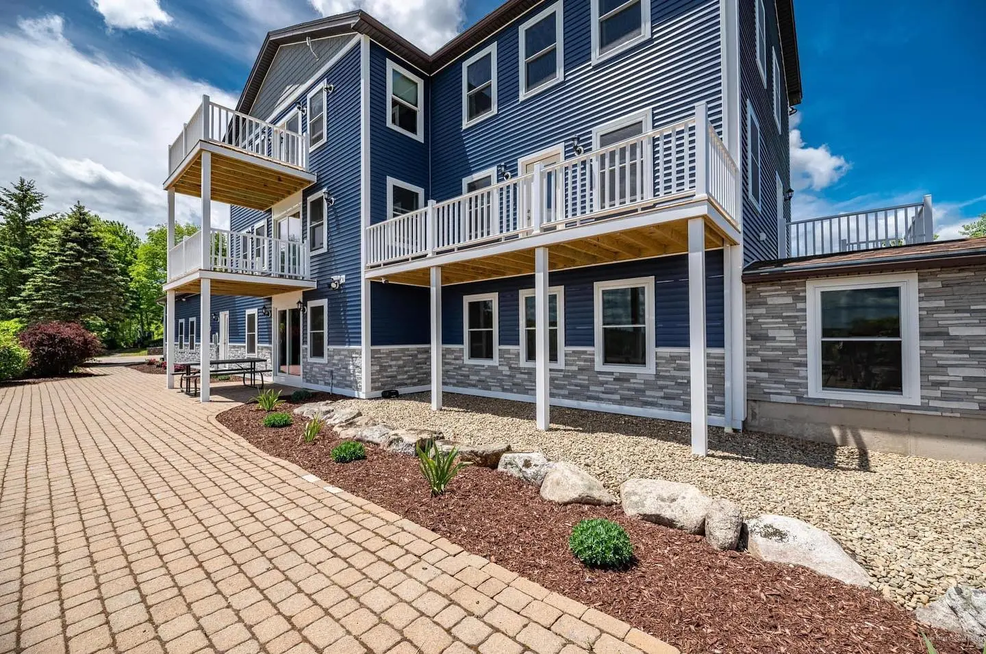 Exterior of the Luxe Liberty estate with balconies and paver walkway